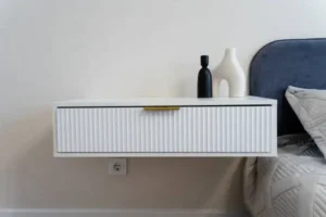 Zwevend nachtkastje van multiplex naast bed